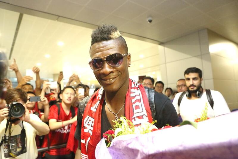 Asamoah Gyan is greeted by fans at Shanghai airport after arriving in the city to finalise his move from Al Ain. 