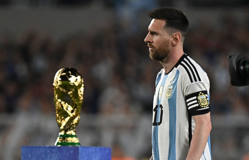 Argentina forward Lionel Messi walks past the World Cup trophy before the friendly football match against Panama. AFP