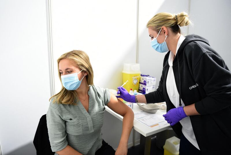 A doctor vaccinates an employee with the Pfizer BioNTech vaccine at the vaccination center of CHEMPARK operator CURRENTA in Leverkusen, western Germany, on June 22, 2021, amid the ongoing coronavirus (Covid-19) pandemic. Since June the prioritisation for vaccination against Covid-19 has been lifted nationwide. Now the company doctors at the sites in the CHEMPARKS of Leverkusen, Krefeld-Uerdingen and Dormagen can vaccinate the approx. 35000 employees. It is a joint initiative of the companies located at the CHEMPARK sites, which include CHEMPARK operator CURRENTA, LANXESS, Bayer and Covestro.  / AFP / Ina FASSBENDER
