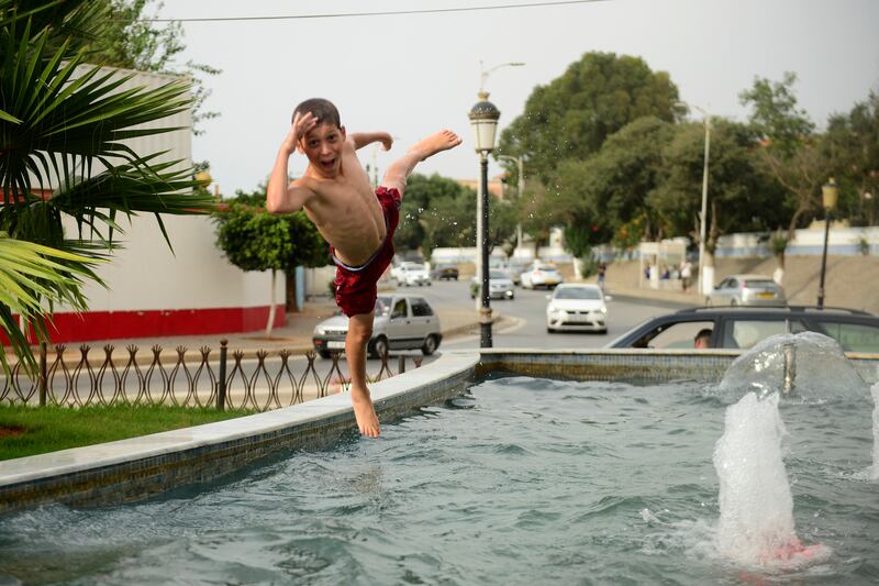 A child plays in a public fountain in Algiers. AP