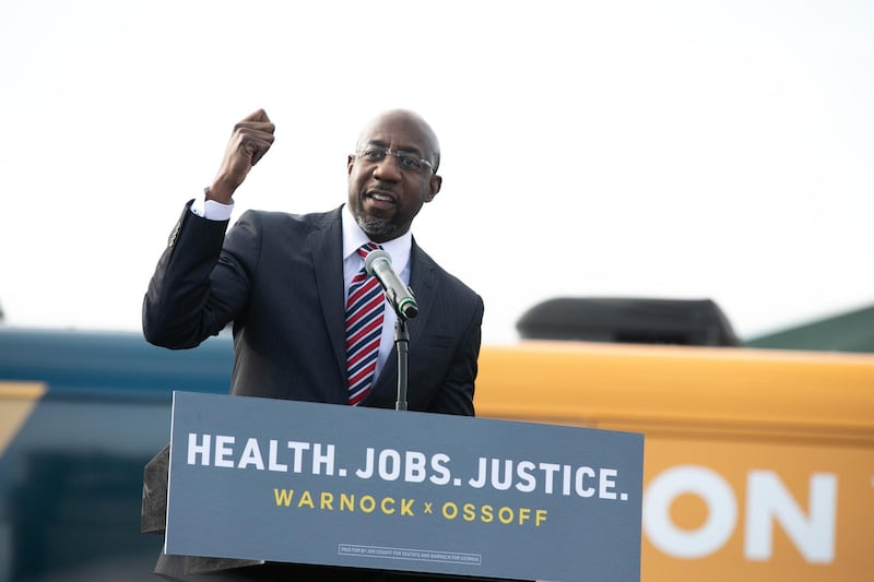 Georgia Democratic Senate candidate Raphael Warnock speaks to the crowd during an "It's Time to Vote" drive-in rally in Stonecrest, Georgia. AFP