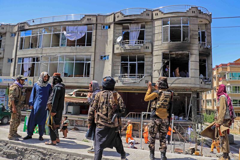 Taliban fighters stand guard at the site of an explosion in front of a Sikh temple, in Kabul on Saturday.  EPA