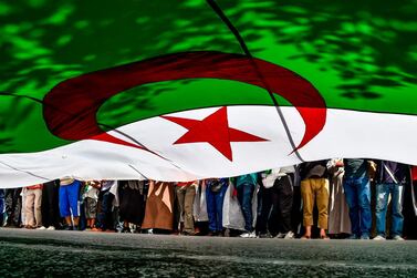 Algerian protesters march with a giant national flag to keep up the pressure on the North African state's ruling. AFP