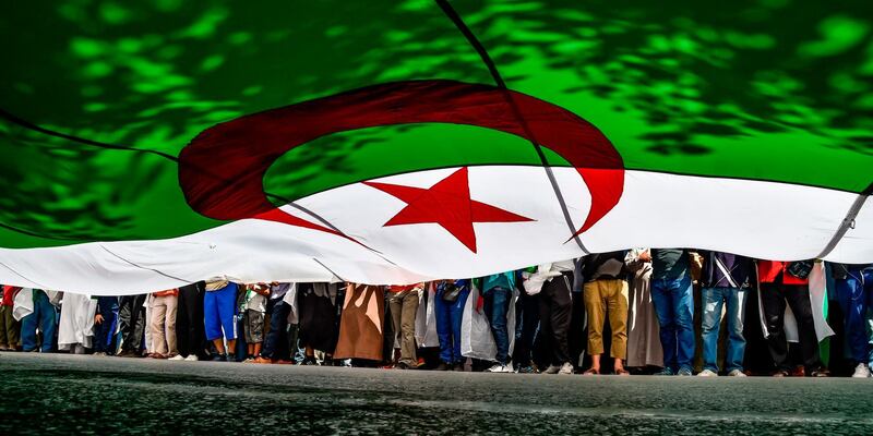 TOPSHOT - Algerian protesters march with a giant national flag during a demonstration in the capital Algiers on May 31, 2019. Protesters are looking to keep up the pressure on the North African state's ruling elite with weekly rallies despite the end of Bouteflika's two-decade rule. / AFP / RYAD KRAMDI                        
