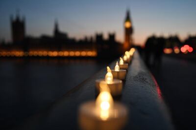 Candles lie along Westminster Bridge in London in memory of the victims of the Westminster attack.  EPA