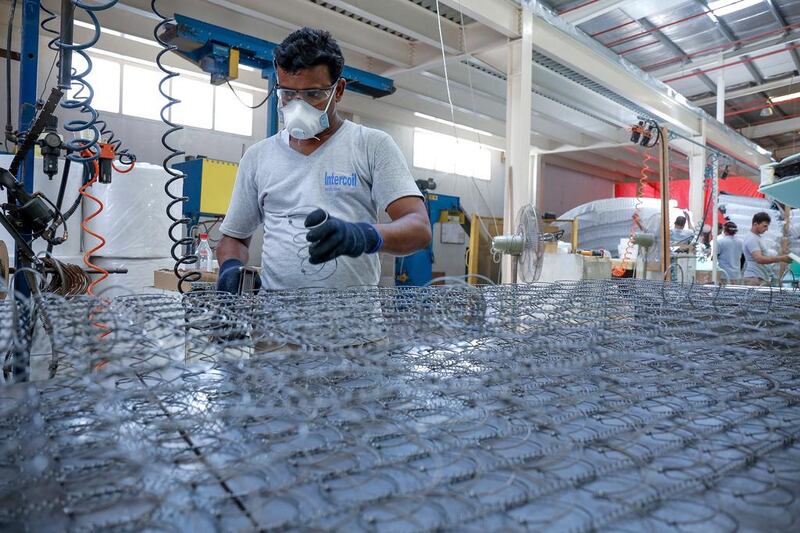 A worker assembles coils for mattresses at Intercoil’s Dubai factory. Victor Besa for The National