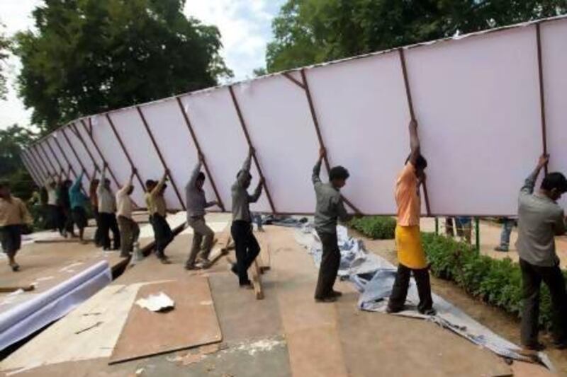 Indian workers carry a giant billboard as they work inside Shalimar Gardens, the venue for a concert by renowned Indian-born orchestra conductor Zubin Mehta, on the outskirts of Srinagar, India, on Tuesday. Dar Yasin / AP Photo