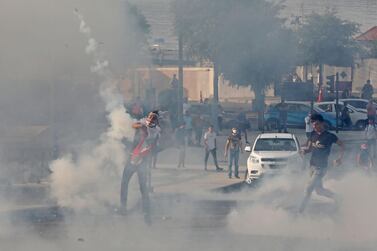 A protester throws back a tear gas canister amid clashes with riot police following a demonstration in central Beirut on June 6, 2020. Protesters poured on to the streets of the Lebanese capital to decry the collapse of the economy, as clashes erupted between supporters and opponents of the Iran-backed Shiite group Hezbollah. AFP