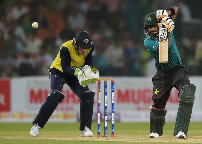 Pakistani batsman Babar Azam (R) plays a shot as World XI wicketerkeeper Tim Paine looks on during the first Twenty20 international match between the World XI and Pakistan at the Gaddafi Cricket Stadium in Lahore on September 12, 2017. / AFP PHOTO / AAMIR QURESHI