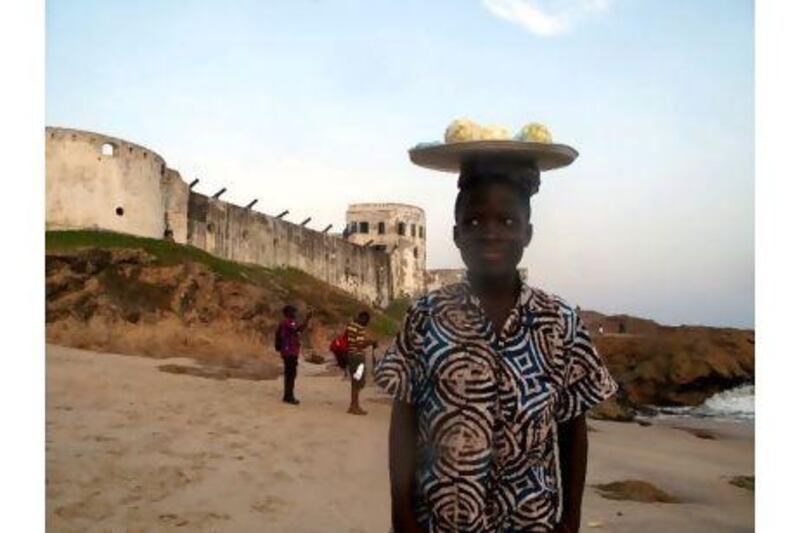 A boy sells oranges on the beach outside Cape Coast Castle in Ghana, a former slaving depot and now a tourist site.