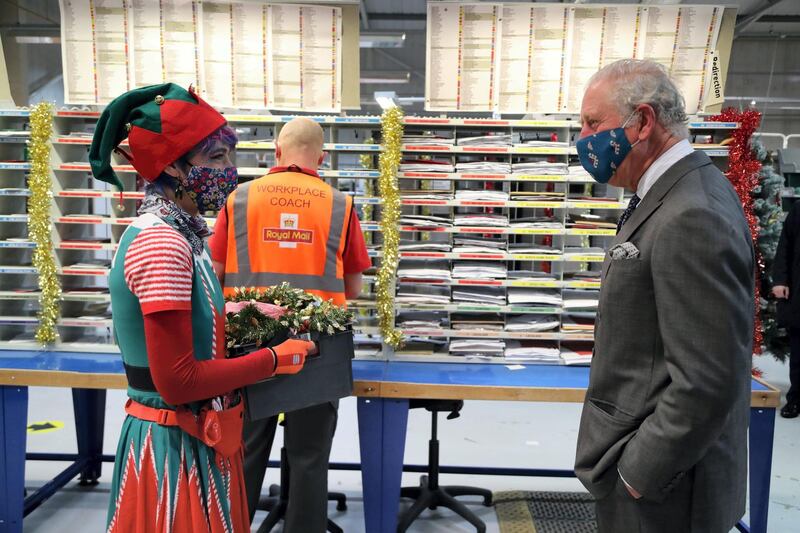 CIRENCESTER, ENGLAND - DECEMBER 18: Prince Charles, Prince of Wales, wearing a mask meets with Royal Mail employee Catherine Griffiths (L) on a visit to the Royal Mail's Delivery Office in Cirencester to recognise the vital public services that the country's postal workers provide, especially during the coronavirus pandemic and in the run-up to Christmas on December 18, 2020 in Cirencester, England.  (Photo by Geoff Caddick - WPA Pool / Getty Images)