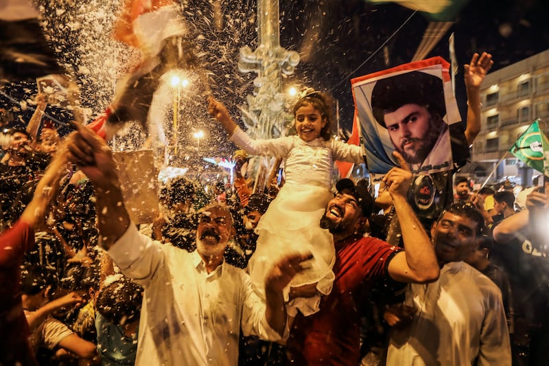 Supporters of Moqtada Al Sadr’s movement celebrate after preliminary results of Iraq’s parliamentary election were announced in Najaf on Monday. Reuters