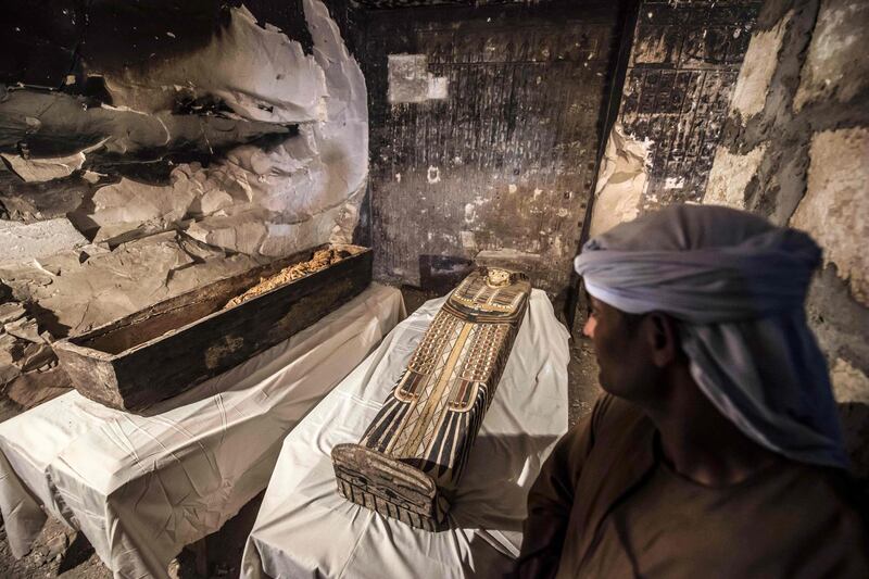An Egyptian worker stands next to an opened intact sarcophagus containing a well-preserved mummy of a woman named Thuya wrapped in linen. AFP