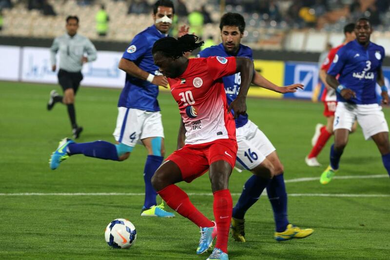 Al Jazira's Felipe Caicedo, centre, fights for the ball against Iran's Esteghlal player Hashem Bekzadeh, right, during their AFC Champions League Group A football match on Tuesday at the Azadi Stadium in Tehran. The match ended in a 2-2 draw. Atta Kenare / AFP / March 18, 2014 

