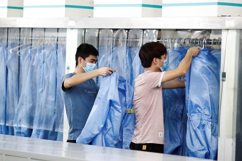 Employees change out their Personal Protective Equipment (PPE) before their lunch break at a factory of Renesas Semiconductor Co. during a government organised tour of the facility following the outbreak of the coronavirus disease (COVID-19), in Beijing, China May 14, 2020. REUTERS/Thomas Peter
