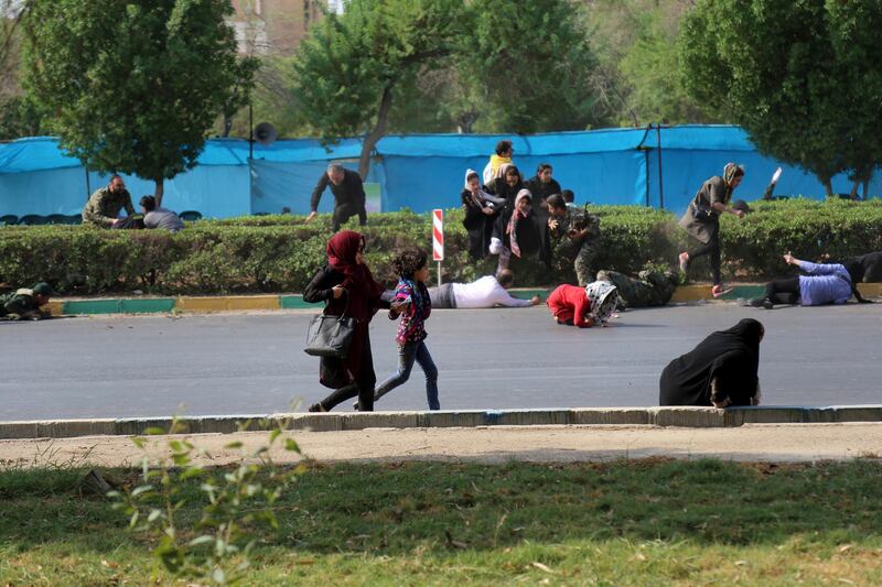 Civilians try to take shelter during the military parade as gunmen started firing. AP Photo