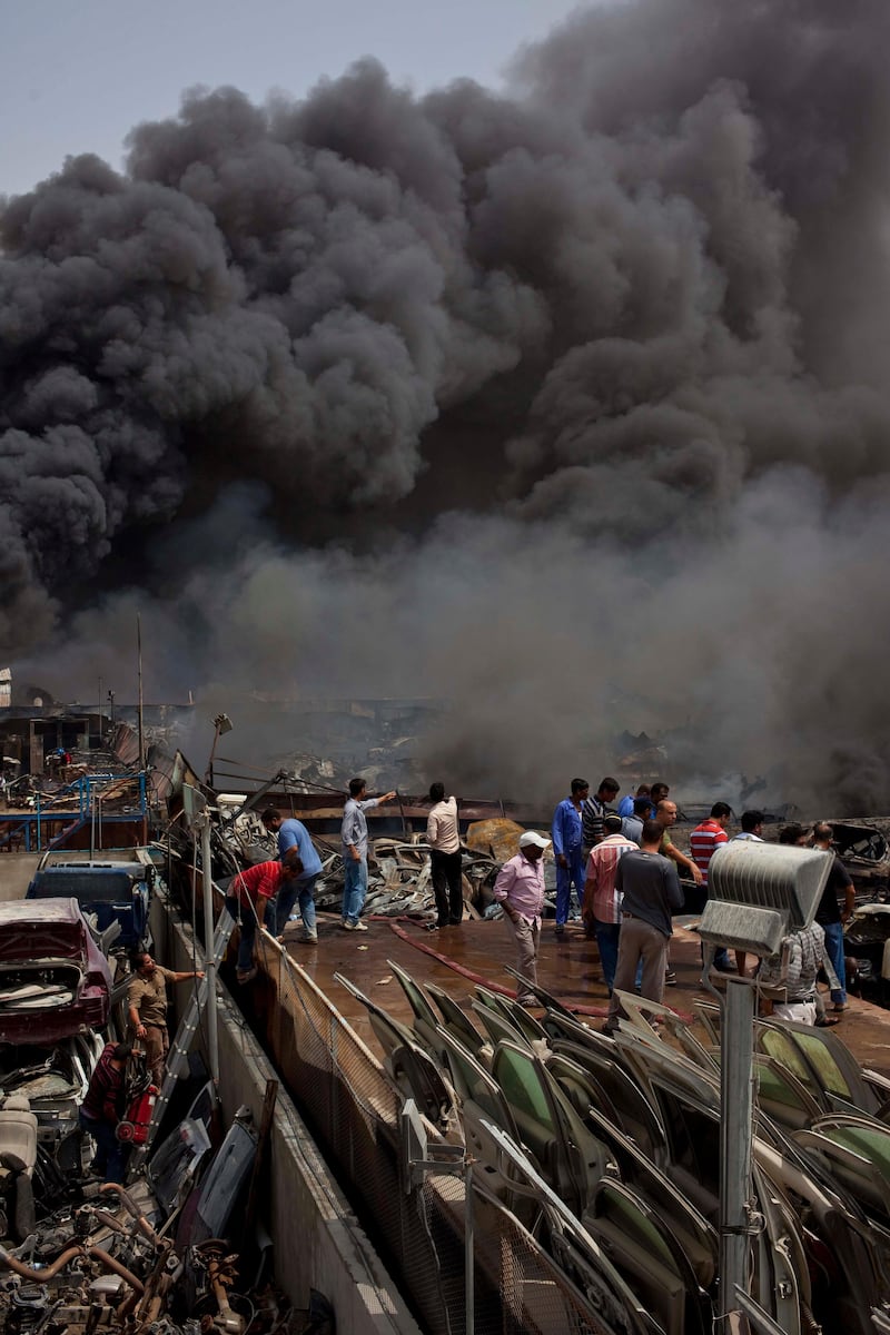 DUBAI, UNITED ARAB EMIRATES,  AUGUST 12, 2013. A fire rages through a car breaker/scrap yard of the Sharjah Industrial area located behing Sharjah City Center. Civilians and workers from the different car shosp helped civial defense to fight the blaze. (ANTONIE ROBERTSON / The National) Journalist Yassin *** Local Caption ***  AR_1208_Sharjah_Fire02.jpg