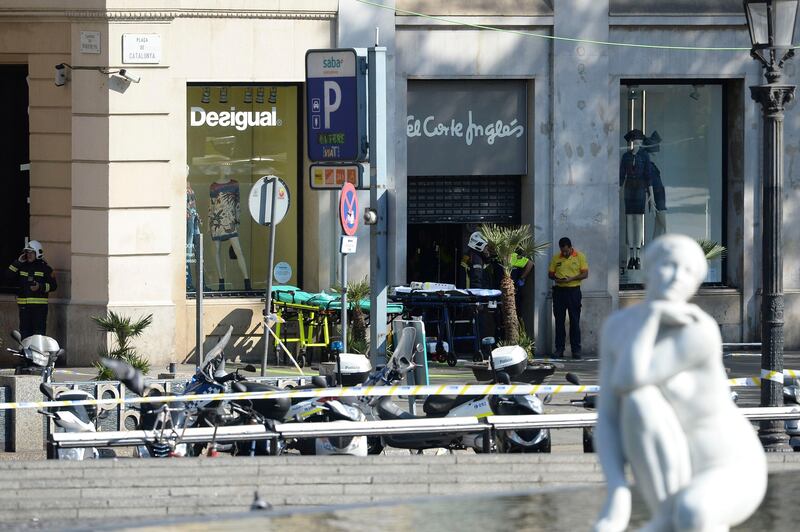Firefighters stand outside an evacuated mall after a van ploughed into a crowd, injuring several people near Las Ramblas in Barcelona. Josep Lago / AFP.