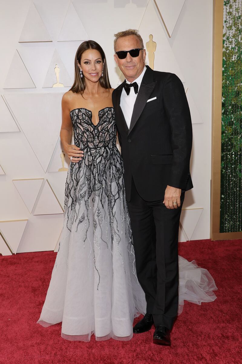 Christine Baumgartner, wearing black and white Tony Ward, and Kevin Costner. AFP