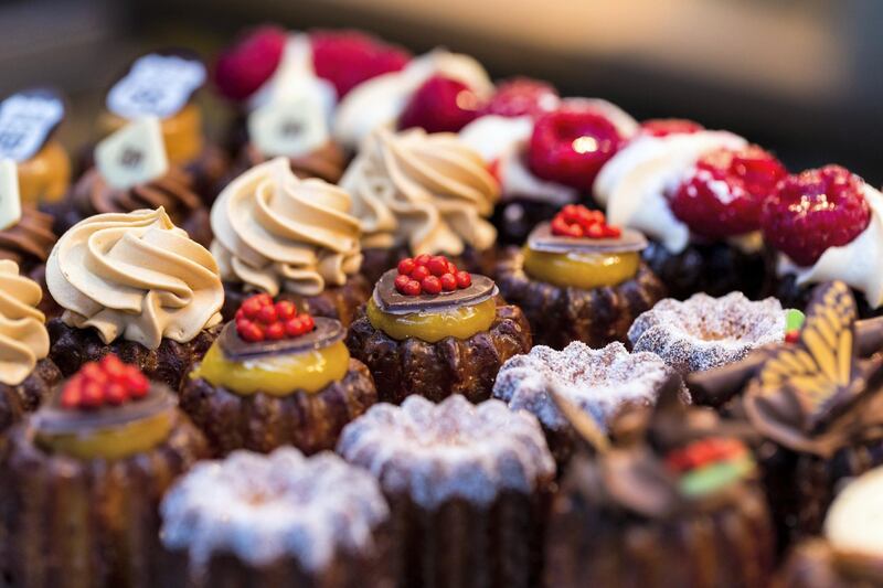 Close up horizontal color image depicting a selection of freshly baked delicious cakes and cupcakes for sale at Borough Market in London, one of the oldest and most popular food markets in the world. The gourmet cakes are topped with all kinds of things, including whipped cream and fresh strawberries. Room for copy space. Getty Images
