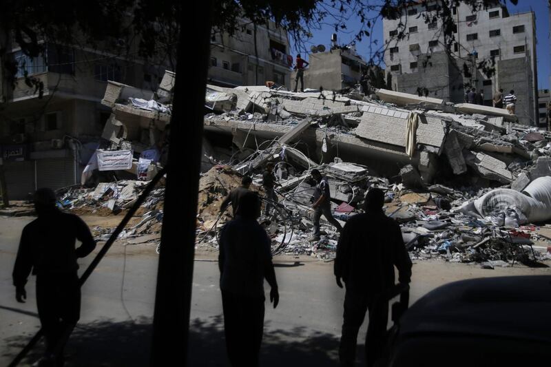 Palestinians sift through the rubble of a Gaza building destroyed during an Israeli airstrike, three days after an Egypt-brokered cease fire agreement..  AFP