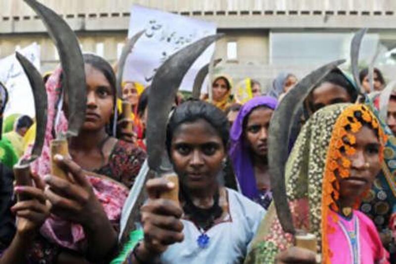Female peasants hold sickles as they protest against the escalating food crisis in Karachi.