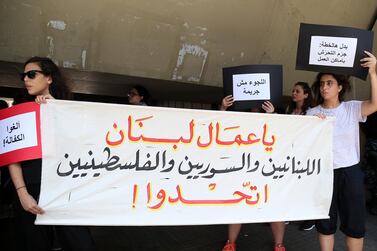 Protesters hold a banner reading in Arabic: 'Lebanese, Syrians and Palestinians workers of Lebanon, unite!' during a protest against the raids and arrests by the Ministry of Labour targeting undocumented workers. EPA