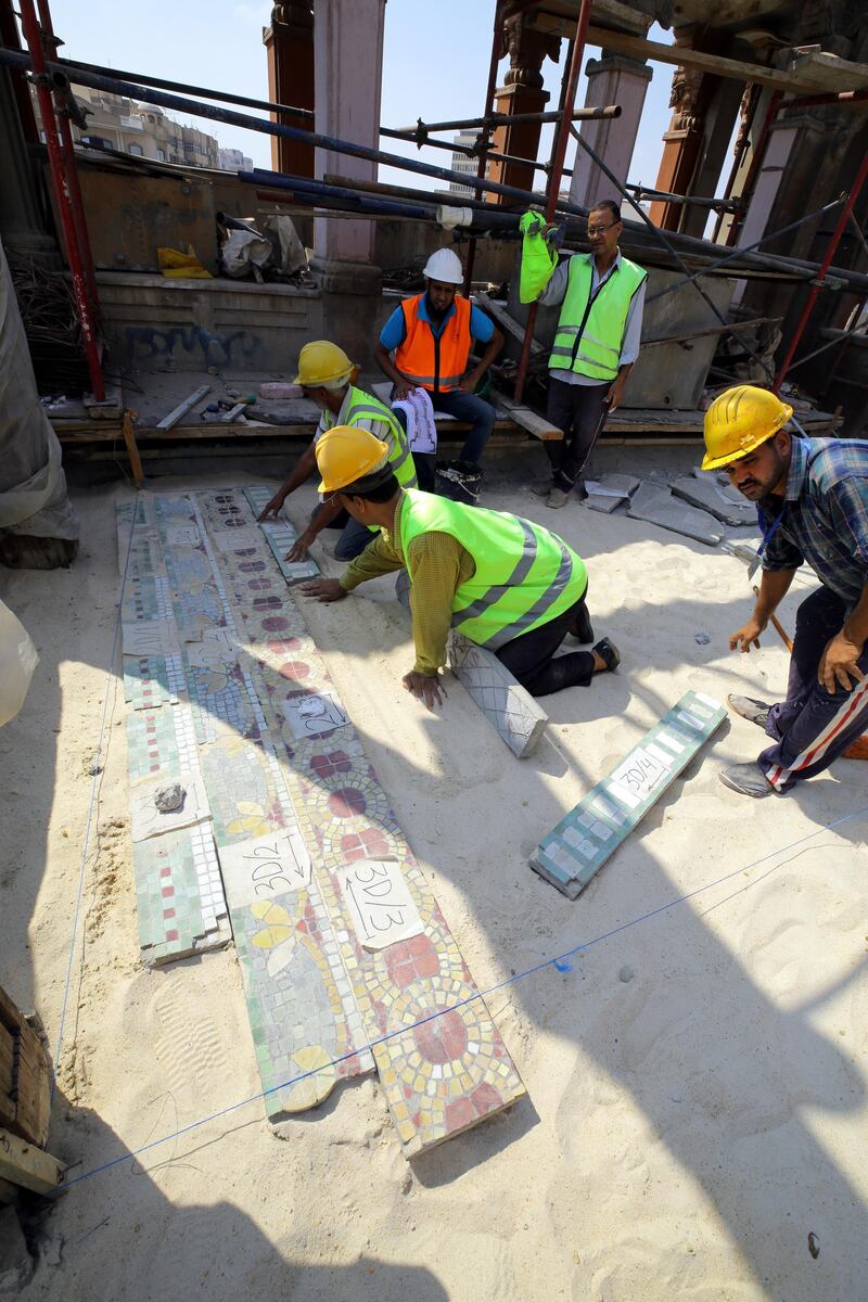 People work on the restoration of tiles in the Baron Palace. EPA