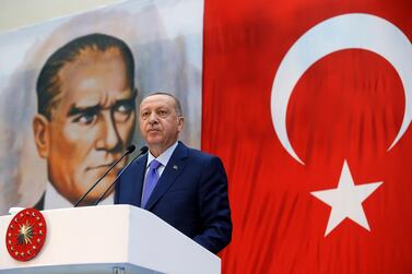 Turkey's President Recep Tayyip Erdogan, backdropped by a poster of modern Turkey's founder Mustafa Kemal Ataturk, speaks during a ceremony in Istanbul, Saturday, Oct. 26, 2019. Presidential Press Service via AP