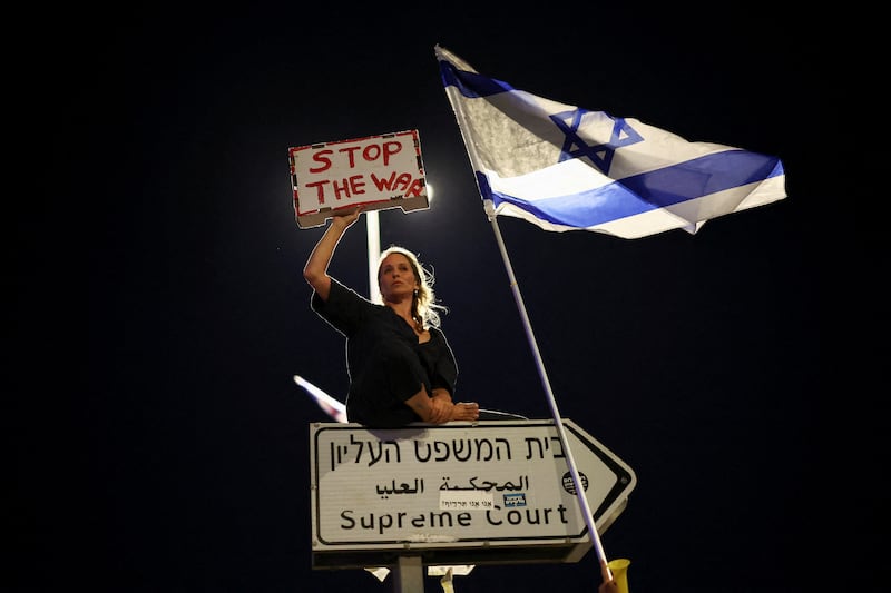 A protester holds a sign during a demonstration against Israeli Prime Minister Benjamin Netanyahu's government, near the Knesset, the Israeli parliament, in Jerusalem. Reuters