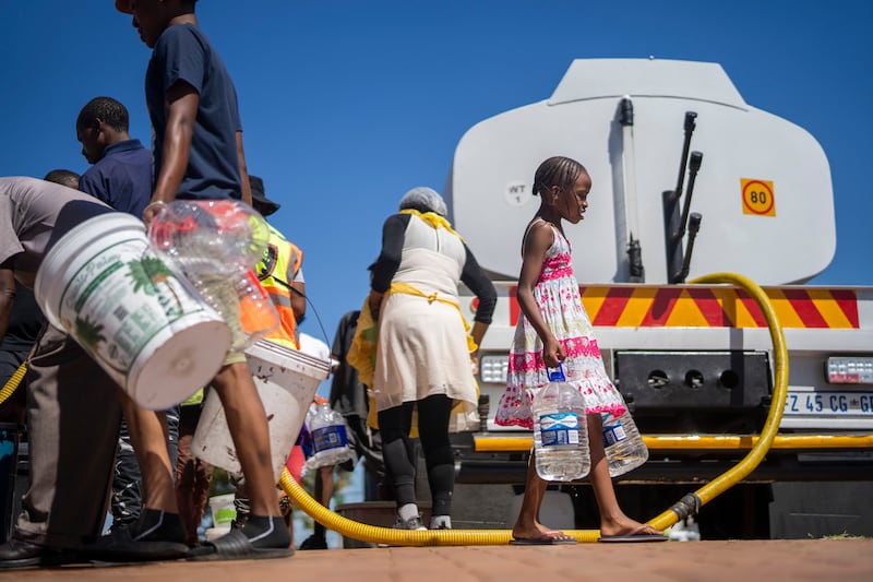 People wait to fill water bottles in Soweto, South Africa, amid a collapse of the country's water system. AP