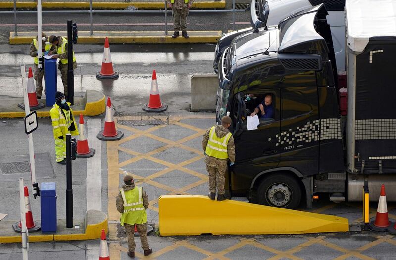 (FILES) In this file photo taken on December 25, 2020 A lorry driver shows their credentials to a member of the British Army, as they enter the Port of Dover, in Dover on the south-east coast of England, as the COVID-19 testing of drivers queueing to depart from the ferry terminal to Europe continues. Truck drivers coming from the UK no longer need a PCR or antigen test to enter France, according to a decree published on March 25, 2021. / AFP / Niklas HALLE'N
