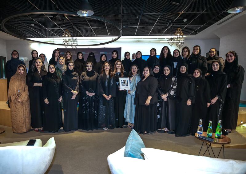 Rima Al Mokarrab and Hana Barakat with the Emirati Women Achievers publication and some of the women featured in the book. 