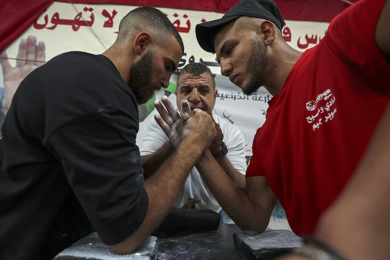 Palestinians take part in a two-day arm wrestling championship in Rammun village, east of Ramallah in the West Bank, on September 9, 2022.  (Photo by ABBAS MOMANI  /  AFP)
