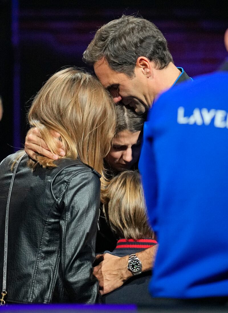 Roger Federer embraces his wife Mirka and their children. AP
