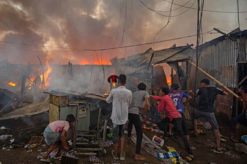 Men attempt to douse a fire that engulfed a slum in Dhaka, Bangladesh. Getty Images