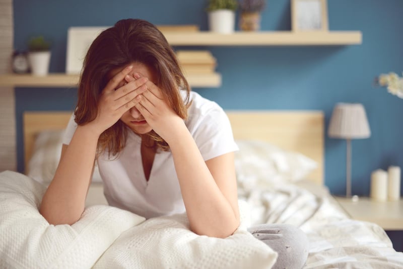 Unhappy girl in a bedroom *** Local Caption ***  hl16ju-headache_sufferer_pg32.jpg