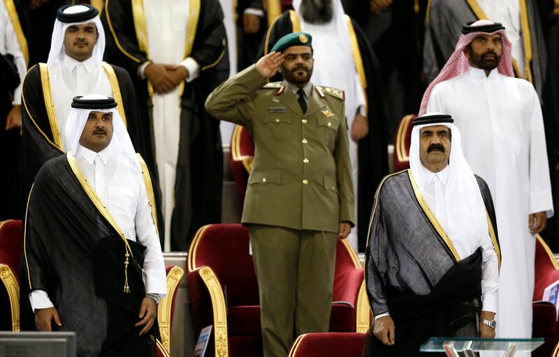 Qatar's Emir Sheikh Hamad bin Khalifa al-Thani (R) stands next to his son Crown Prince Sheikh Tamim before the Emir Cup final match between Al-Sadd and Al-Rayyan at Khalifa stadium in Doha in this May 18, 2013 file photo. The emir of Qatar told his family on June 24, 2013 he would hand power to his son, al Jazeera reported, preparing the wealthy gas-exporting Gulf Arab country for a highly unusual step in a region where hereditary rule normally means for life. REUTERS/Fadi Al-Assaad/Files (QATAR - Tags: ROYALS POLITICS) *** Local Caption ***  QAT04_QATAR-EMIR-_0624_11.JPG