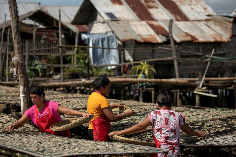Women dry fish at Tagburos village, which was visited by US  Vice President Kamala Harris, in the Philippines. Reuters