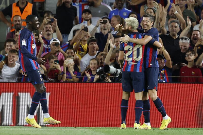 Robert Lewandowski celebrates with Sergi Roberto and Ousmane Dembele after scoring Barcelona's third goal. EPA