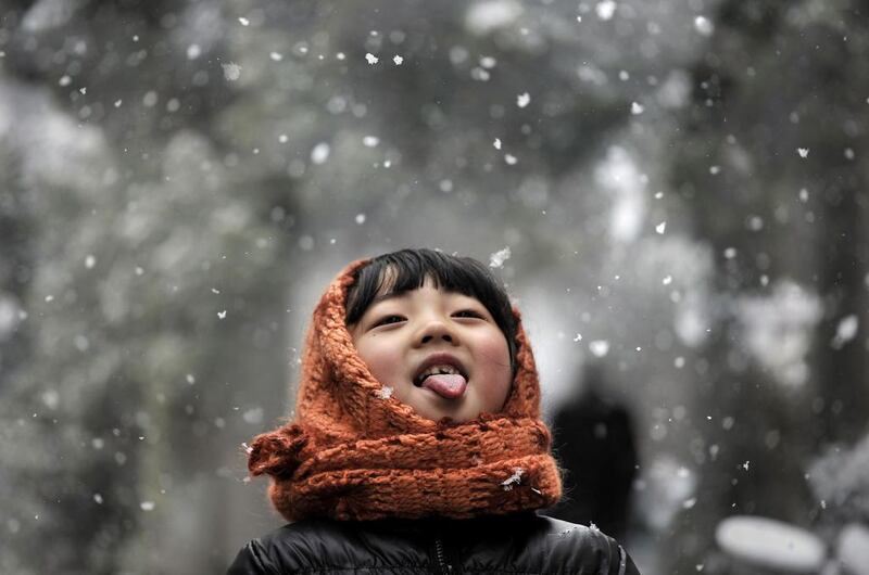 A girl catches snowflakes on a street in Hefei, Anhui province, China, on February 13, 2014. Stringer / Reuters