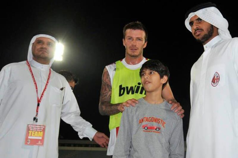 Italian soccer club AC Milan's new loan-signing David Beckham poses with fans after his first training session with the team at Al Nasr Stadium in Dubai, December 30, 2008. AC Milan arrived in the UAE on Monday ahead of their winter training camp which will run from Tuesday to January 6, 2009.  REUTERS/Jumana El Heloueh (UNITED ARAB EMIRATES)