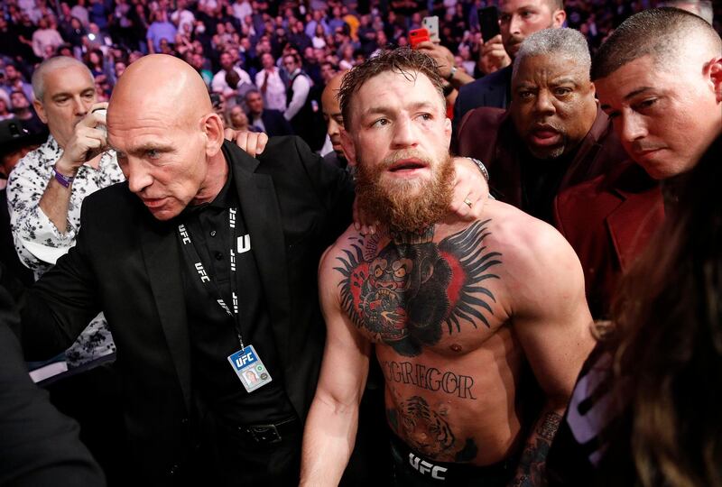 Conor McGregor is escorted from the cage area after fighting Khabib Nurmagomedov in a lightweight title mixed martial arts bout at UFC 229 in Las Vegas, Saturday, Oct. 6, 2018. Nurmagomedov won the fight by submission during the fourth round to retain the title. (AP Photo/John Locher)
