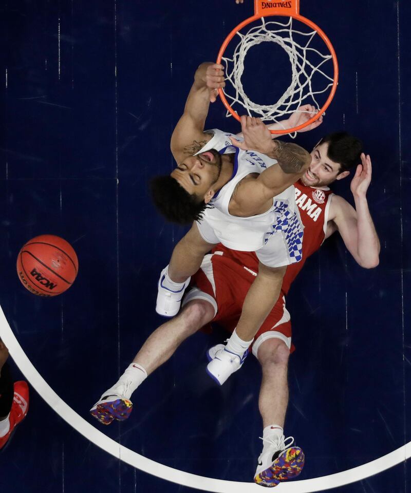 Alabama guard Riley Norris watches from the floor as Kentucky forward Nick Richards dunks the ball above him in the first half of an NCAA college basketball game at the Southeastern Conference tournament  in Nashville, Tenn.  AP