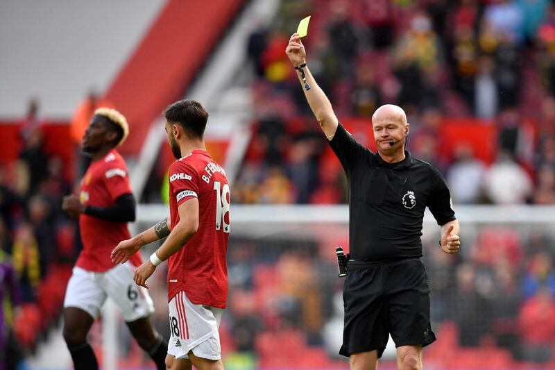 Referee Lee Mason shows a yellow card to United's Bruno Fernandes. AFP