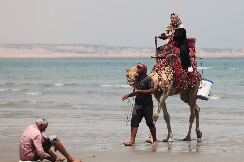 A tourist rides a camel along the beach on Iran's Qeshm island in the Arabian Gulf. All photos by AFP