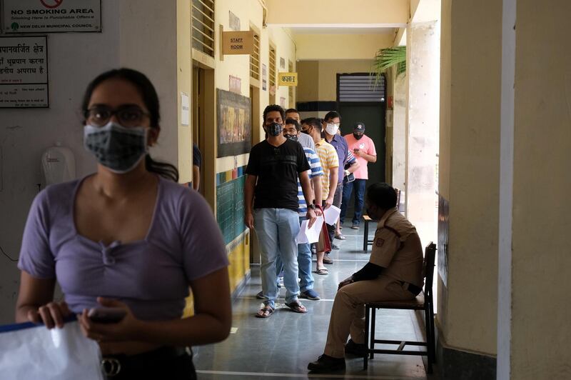 Students who are preparing to study abroad wait at a coronavirus vaccination centre in a school in New Delhi, India. Bloomberg