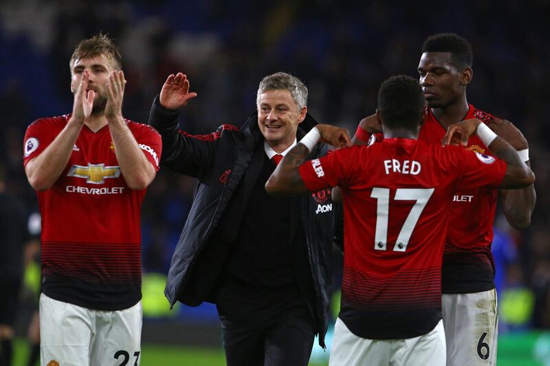 Manchester United's Norwegian caretaker manager Ole Gunnar Solskjaer (C) celebrates with his players on the pitch after the English Premier League football match between between Cardiff City and Manchester United at Cardiff City Stadium in Cardiff, south Wales on  December 22, 2018. - Manchester United won the game 5-1. (Photo by Geoff CADDICK / AFP) / RESTRICTED TO EDITORIAL USE. No use with unauthorized audio, video, data, fixture lists, club/league logos or 'live' services. Online in-match use limited to 120 images. An additional 40 images may be used in extra time. No video emulation. Social media in-match use limited to 120 images. An additional 40 images may be used in extra time. No use in betting publications, games or single club/league/player publications. / 