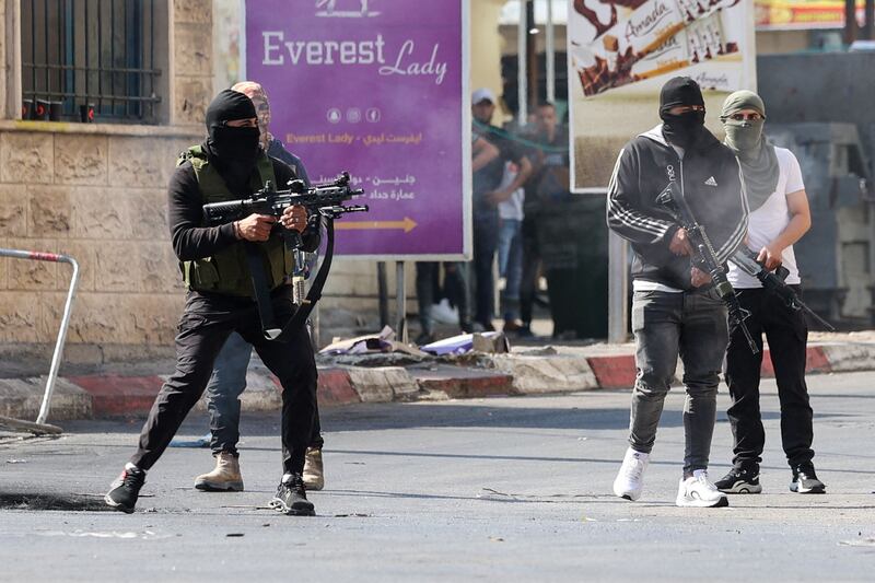 Palestinian armed militants take up position during a confrontation with the Israeli army. AFP