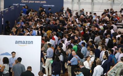 FILE - In this Sept. 17, 2019, file photo job seekers line up to speak to recruiters during an Amazon job fair in Dallas. On Friday, Oct. 4, the U.S. government issues the September jobs report. Amazon says it hired 200,000 people for the busy holiday shopping season, double the amount of people it hired last year. (AP Photo/LM Otero, File)